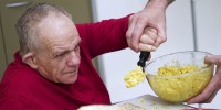 Man being helped to eat