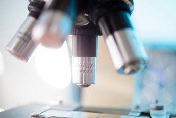 Side view of a microscope above a slide