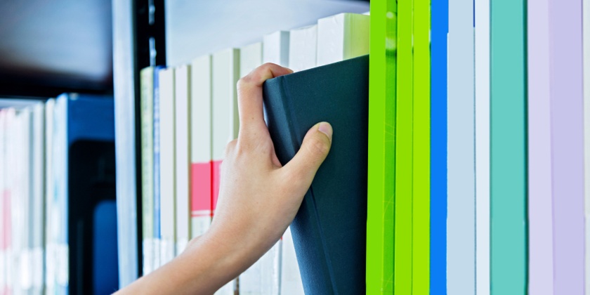 Hand choosing book from a shelf