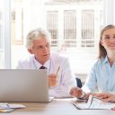 Four people of mixed ages having a discussion in a business setting