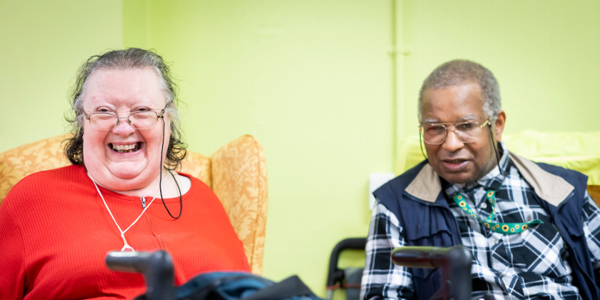 Two happy looking people in a care home setting